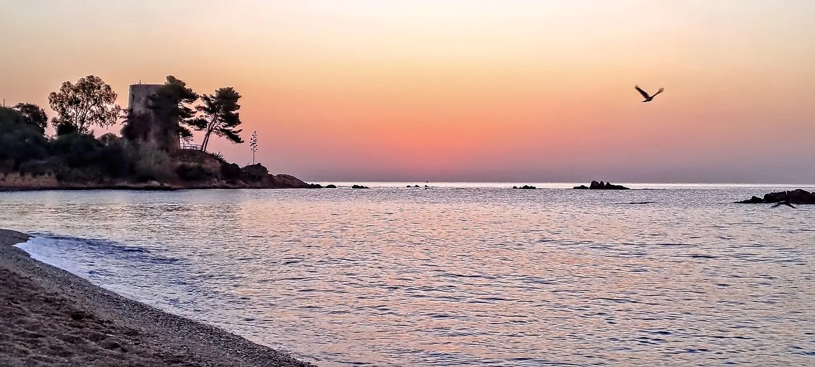 L'alba sulla spiaggia di Santa Maria Navarrese, con la torre sul promontorio